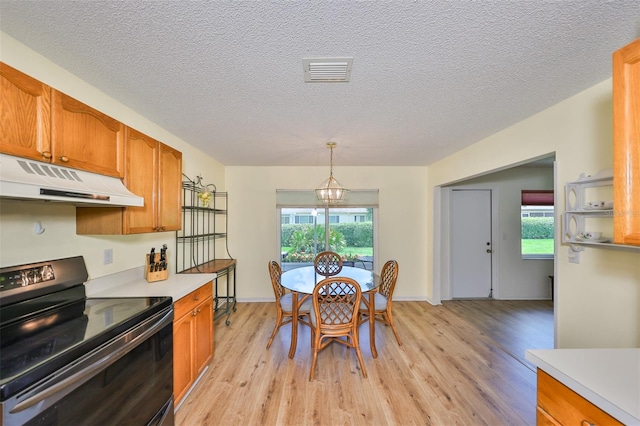 kitchen featuring light hardwood / wood-style floors, a healthy amount of sunlight, black / electric stove, and an inviting chandelier