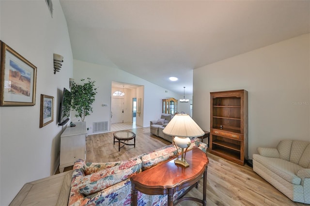 living room with light hardwood / wood-style flooring and lofted ceiling