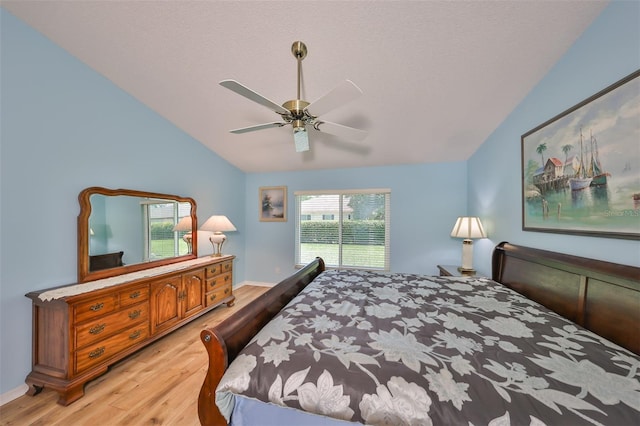 bedroom with ceiling fan, light hardwood / wood-style floors, and lofted ceiling