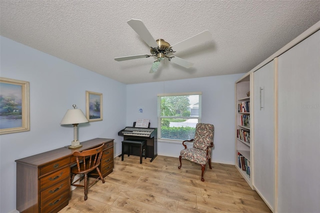 office area featuring ceiling fan, a textured ceiling, and light hardwood / wood-style flooring