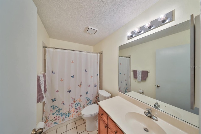 bathroom featuring toilet, tile patterned flooring, vanity, walk in shower, and a textured ceiling