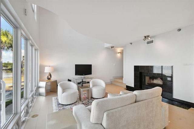 living area with visible vents, a fireplace, and stairway