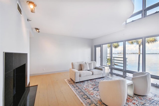 living room featuring a water view and light hardwood / wood-style floors