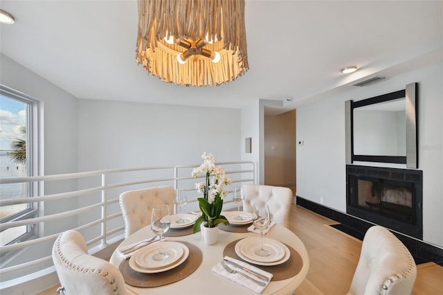 dining room featuring light wood-type flooring and an inviting chandelier