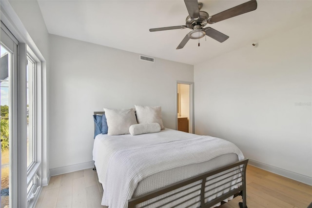 bedroom with visible vents, baseboards, light wood-style floors, and a ceiling fan