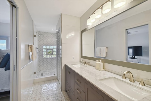 ensuite bathroom with a sink, double vanity, ensuite bathroom, and a tile shower