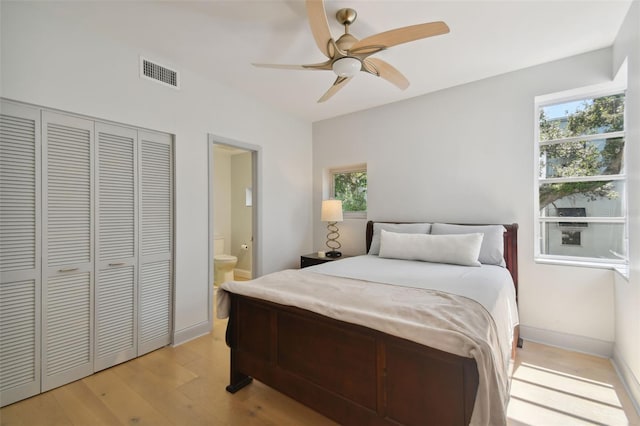 bedroom with a closet, ceiling fan, ensuite bathroom, and light hardwood / wood-style floors