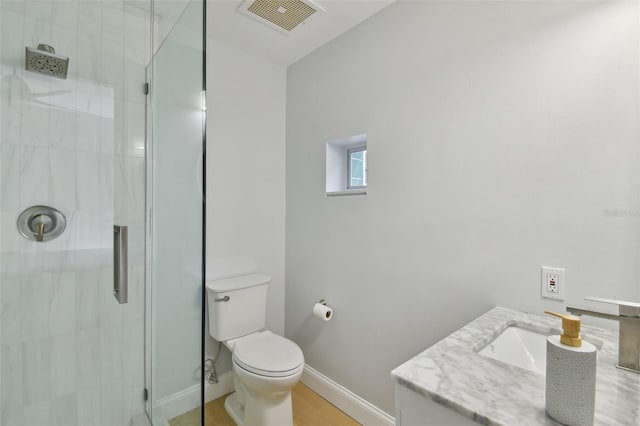 bathroom with vanity, hardwood / wood-style floors, toilet, and a shower with shower door