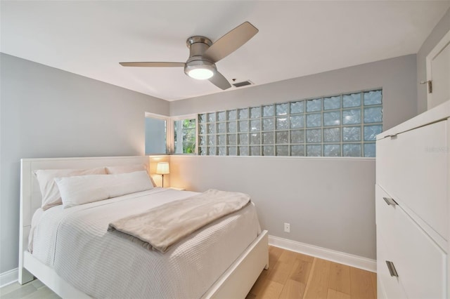 bedroom with ceiling fan, visible vents, baseboards, and light wood-style flooring