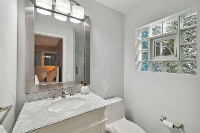 half bath with a wealth of natural light, toilet, and vanity