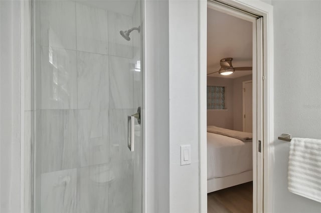 bathroom with wood-type flooring, ceiling fan, and a shower with shower door