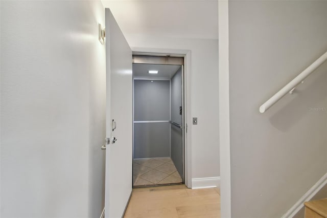 hall with baseboards and light wood-style flooring