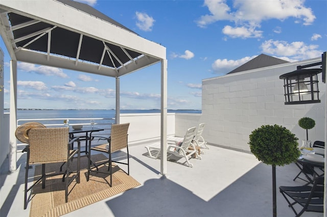 view of patio with a water view and a view of the beach