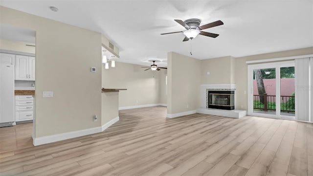 unfurnished living room featuring ceiling fan and light wood-type flooring