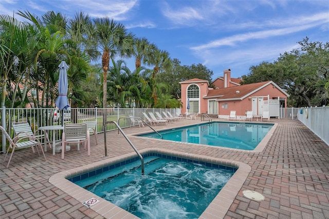 view of pool featuring a patio and a hot tub