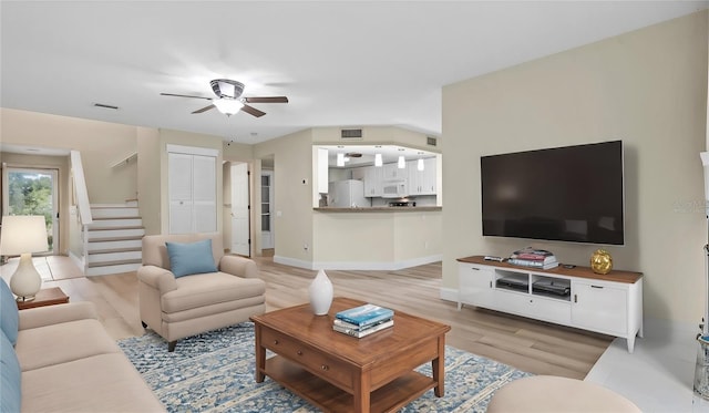 living room with ceiling fan and light hardwood / wood-style floors