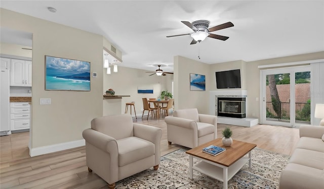 living room with ceiling fan and light hardwood / wood-style floors