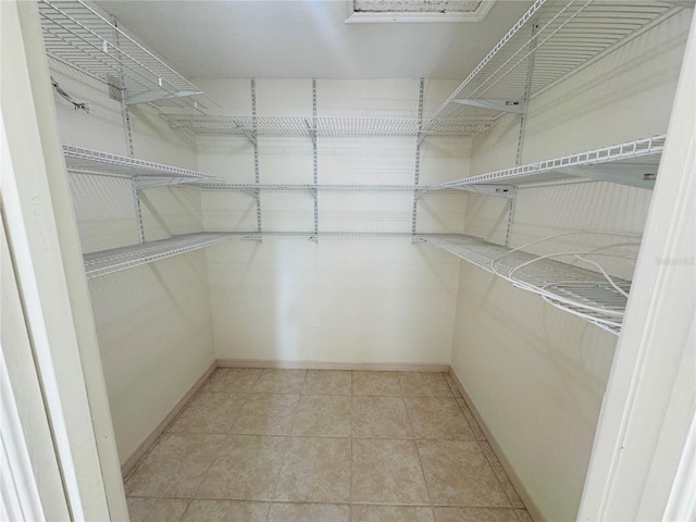 walk in closet with light tile patterned floors