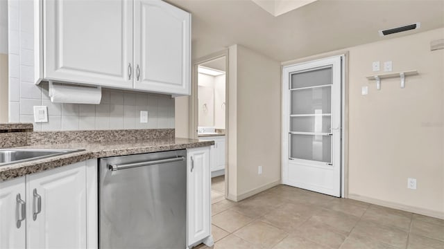 kitchen featuring backsplash, white cabinetry, light tile patterned floors, and stainless steel dishwasher