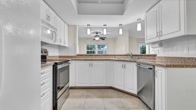 kitchen with pendant lighting, sink, ceiling fan, appliances with stainless steel finishes, and white cabinetry