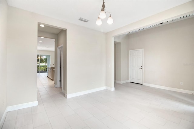 empty room with a notable chandelier