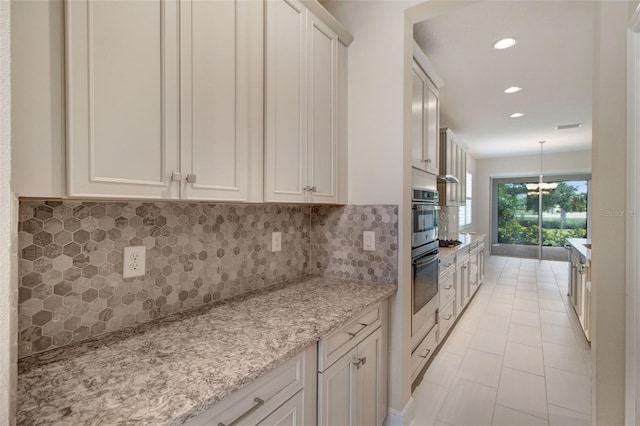 kitchen featuring light stone countertops, white cabinetry, and tasteful backsplash