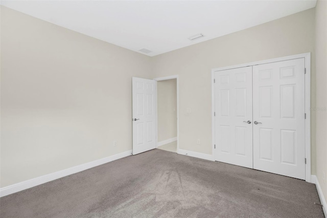 unfurnished bedroom with carpet flooring and a closet