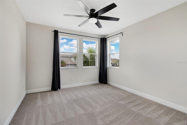 empty room featuring light colored carpet and ceiling fan