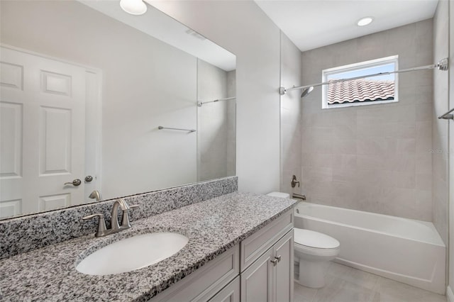 full bathroom with vanity, tiled shower / bath combo, and toilet