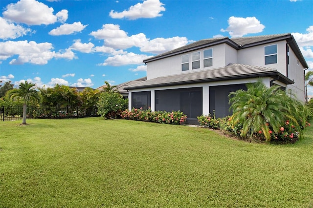 view of home's exterior with a yard and a sunroom