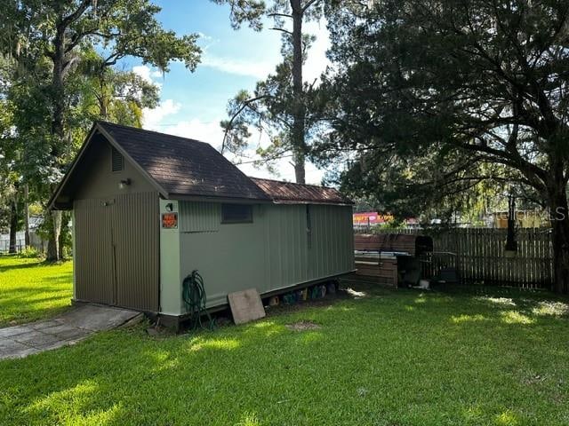 exterior space featuring a lawn and a storage unit