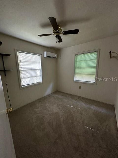 empty room featuring ceiling fan, carpet floors, a wall unit AC, and a healthy amount of sunlight