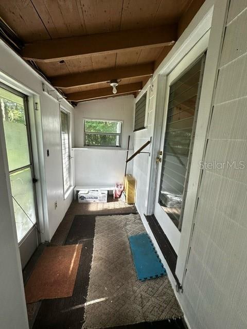 unfurnished sunroom with vaulted ceiling with beams and wooden ceiling