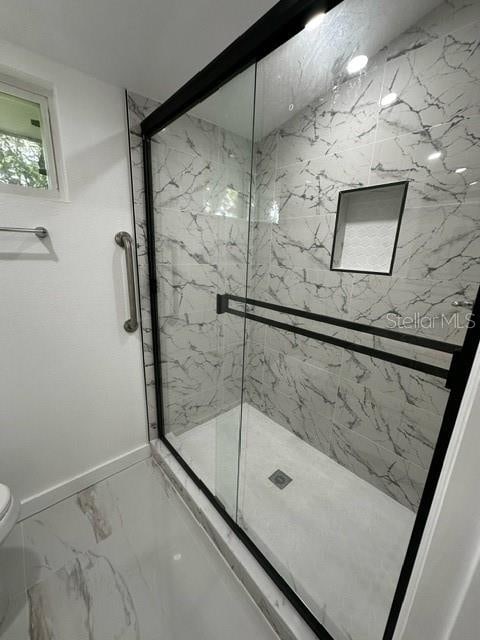 bathroom with toilet, tile patterned flooring, and a shower with shower door