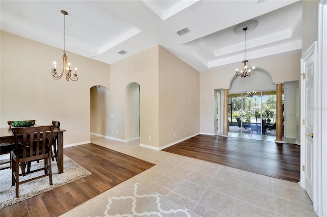 interior space with a raised ceiling, a notable chandelier, and light hardwood / wood-style floors