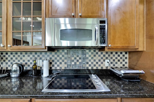 kitchen with black electric cooktop, dark stone countertops, and decorative backsplash