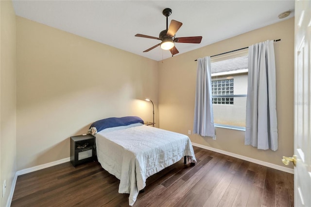 bedroom with dark wood-type flooring, ceiling fan, and multiple windows