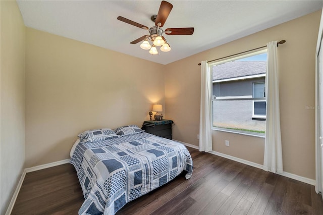 bedroom with ceiling fan, dark hardwood / wood-style floors, and multiple windows