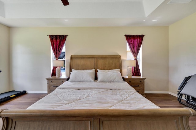 bedroom with multiple windows, ceiling fan, and dark wood-type flooring