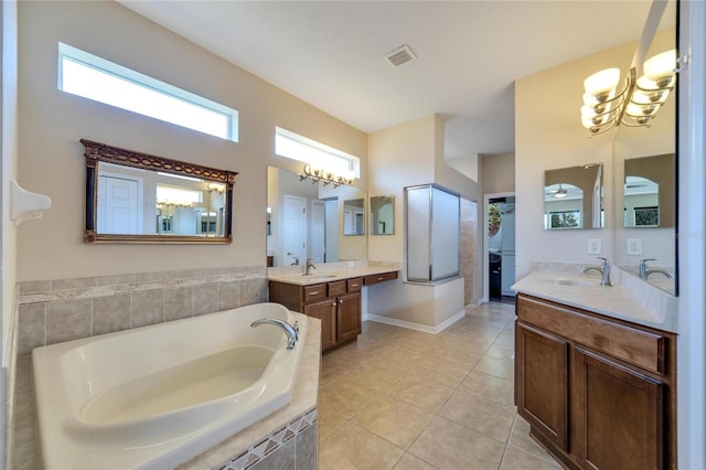 bathroom featuring vanity, tile patterned floors, and tiled bath