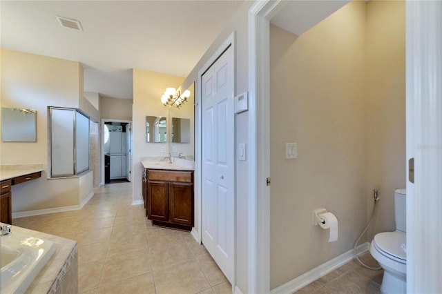 bathroom featuring tiled tub, vanity, toilet, and tile patterned floors