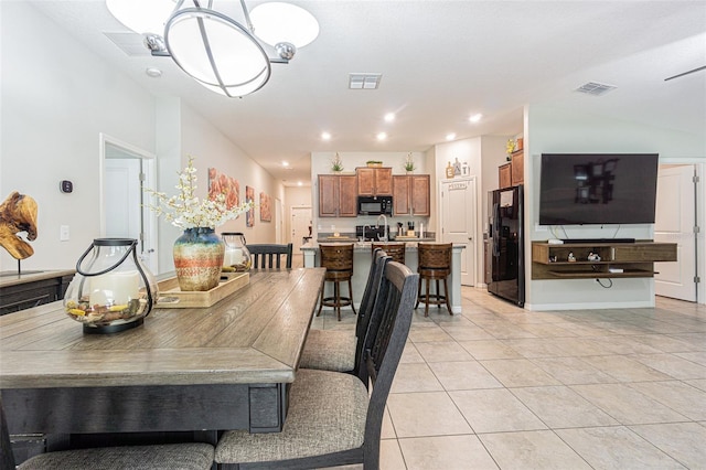 dining area featuring sink, a notable chandelier, and light tile patterned flooring