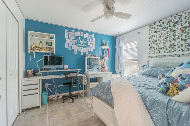 tiled bedroom featuring a textured ceiling, a closet, and ceiling fan