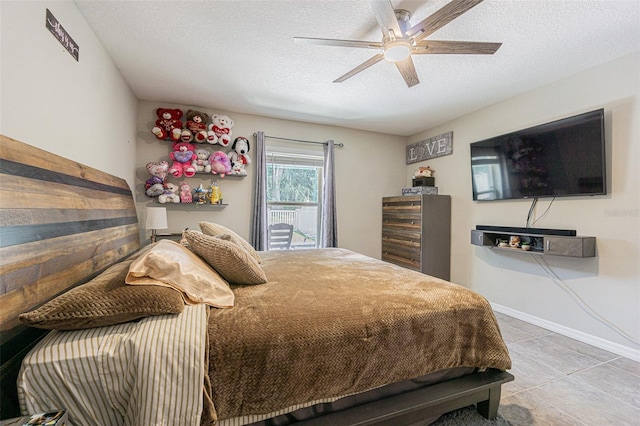 tiled bedroom featuring a textured ceiling and ceiling fan