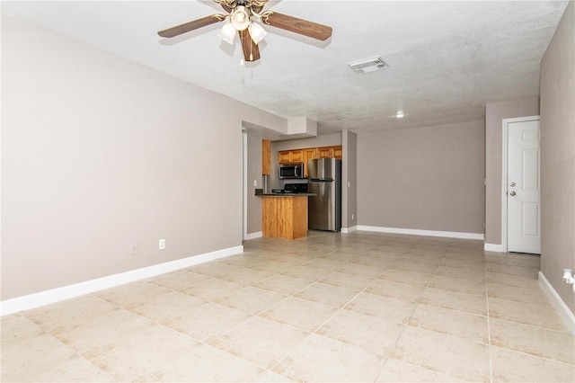 empty room with ceiling fan and light tile patterned floors