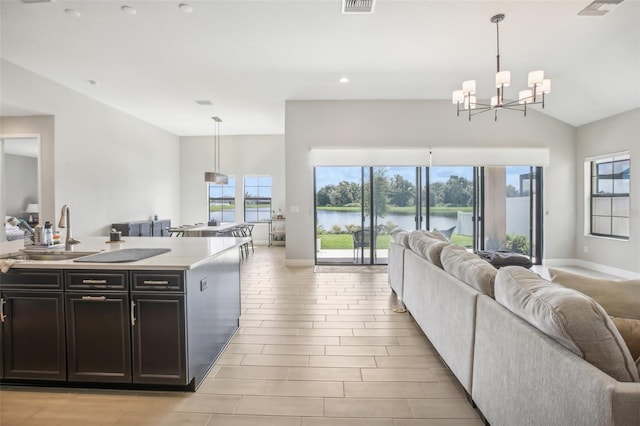 kitchen with open floor plan, light countertops, a sink, and a water view