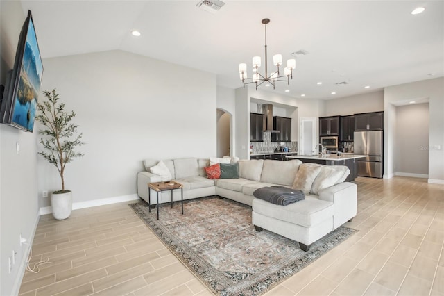 living room featuring arched walkways, visible vents, vaulted ceiling, and baseboards
