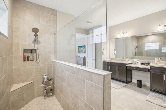 bathroom featuring tiled shower, tile patterned flooring, and vanity