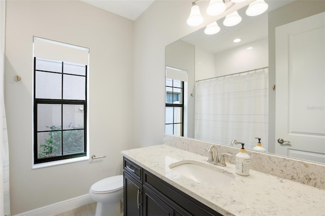 bathroom featuring vanity, toilet, a healthy amount of sunlight, and curtained shower