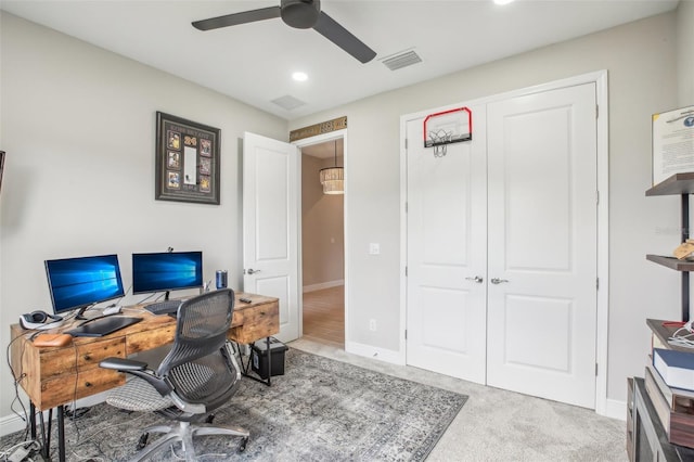 carpeted office space with visible vents, ceiling fan, and baseboards